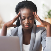 Afro businesswoman massaging temple, trying to concentrate on work
