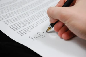 hand signing contract with pen