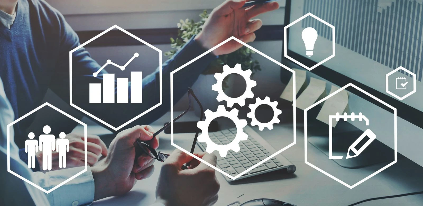Zwei Personen arbeiten an einem Schreibtisch mit einem Computer, umgeben von Symbolen für Geschäftsprozesse, Diagramme und Zahnräder.
